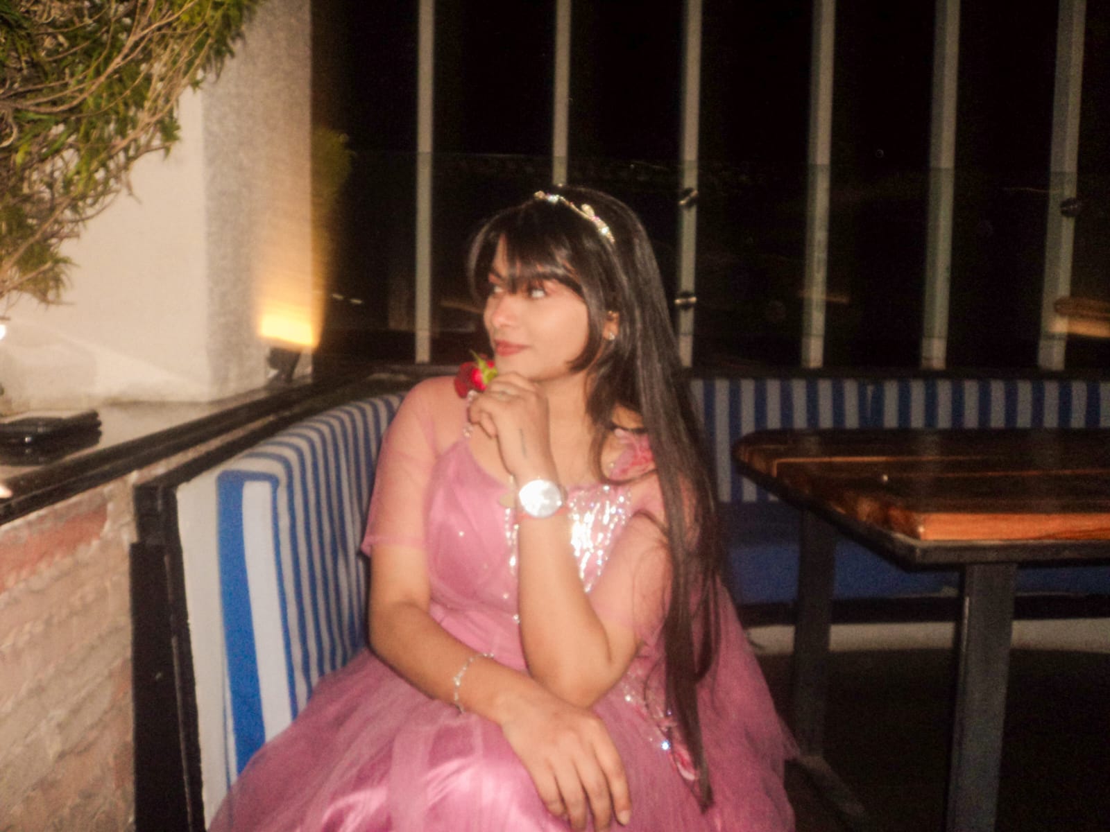 Sanskriti holding a rose at dinner