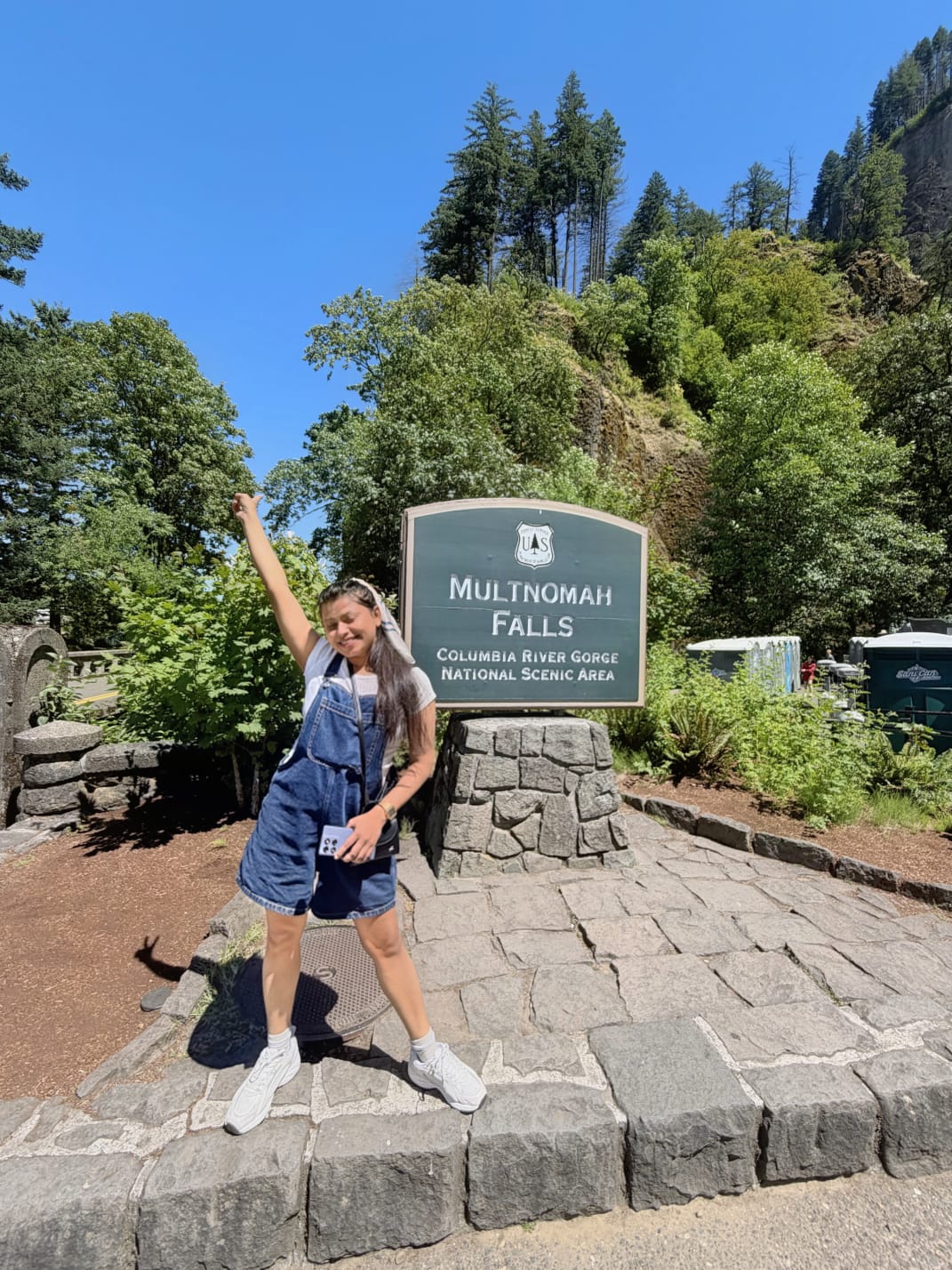 Sanskriti celebrating next to the Multnomah Falls sign