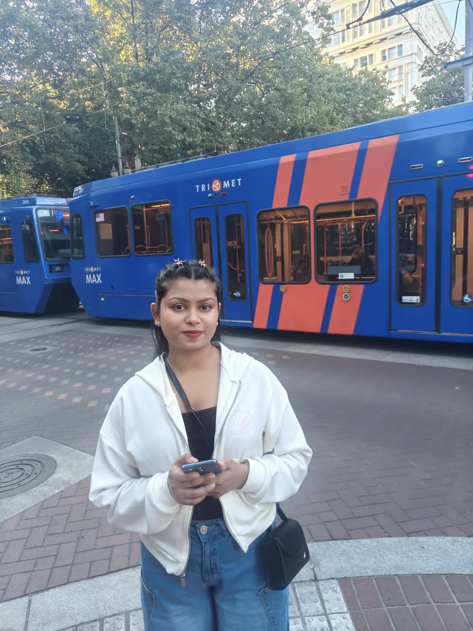 Sanskriti in front of a Portland MAX tram