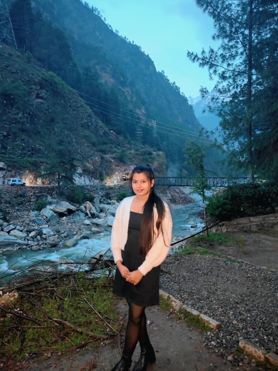 Sanskriti by a river at dusk in the mountains